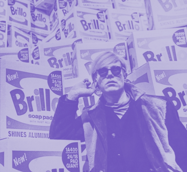 Image of Andy Warhol in front of Brillo boxes