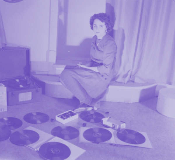 A young women posing with phonograph records and a record player.